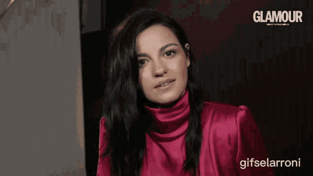 a woman wearing a pink turtleneck is featured in a glamour magazine