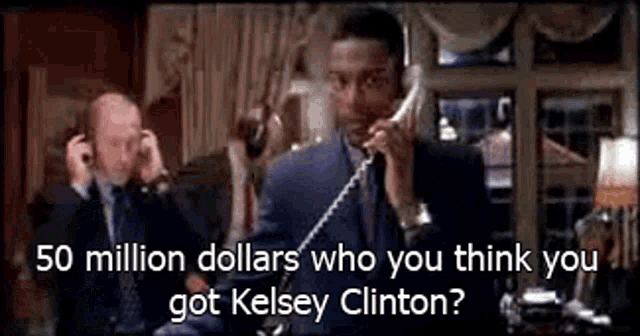 a man in a suit is talking on a phone while another man looks on