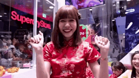 a woman in a red dress is standing in front of a store that says superdry store