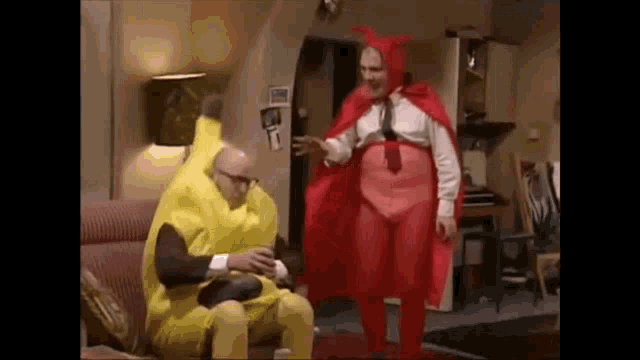 a man in a banana costume and a man in a red cape are sitting on a couch .