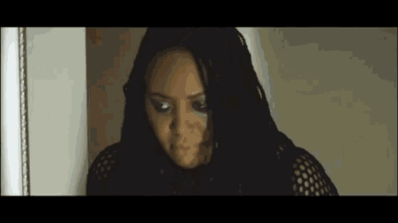 a close up of a woman 's face with a tear in her eye
