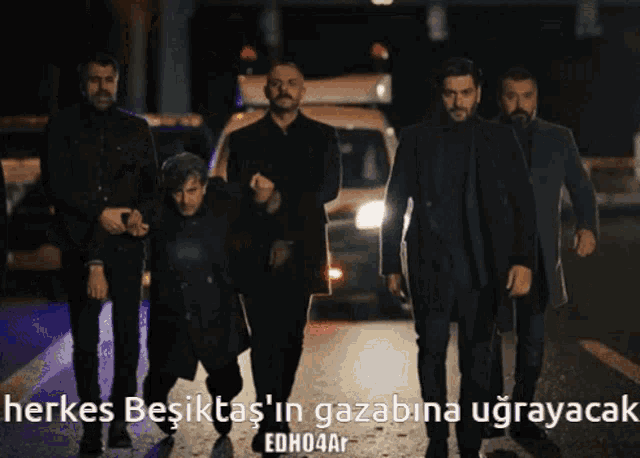 a group of men are walking down a street with the words herkes besiktas ' in gazabina ugrayacak