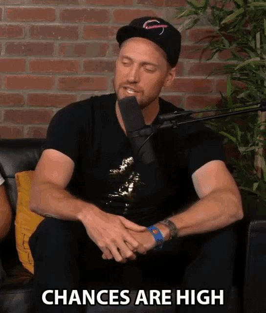 a man sitting in front of a microphone with the words " chances are high " written below him
