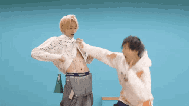 a man is kicking another man in the stomach who is wearing a hoodie that says outdoo