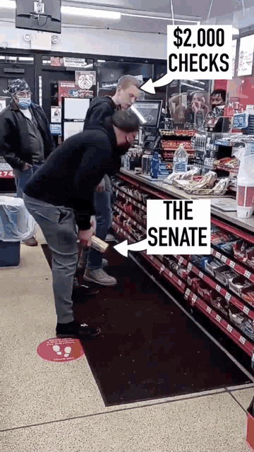 a man standing in a grocery store with a sign that says $ 2,000 checks and the senate