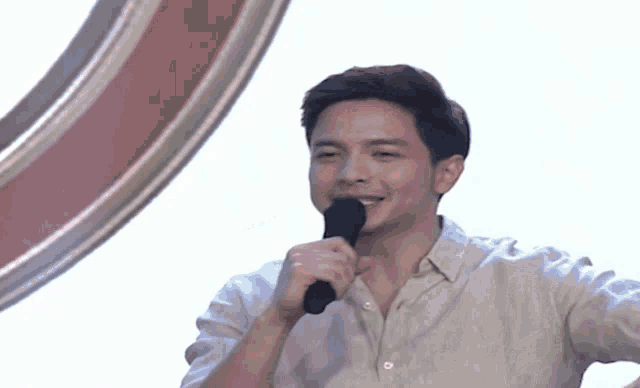 a man in a white shirt is holding a microphone