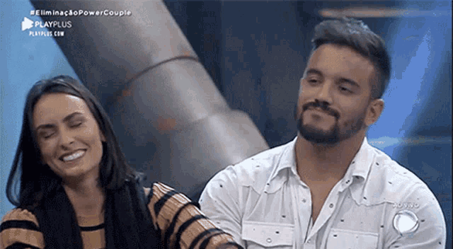a man and a woman are sitting next to each other on a stage .