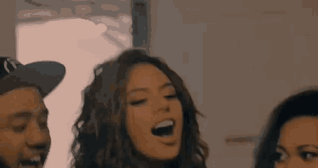 a group of people are standing next to each other laughing and having fun .