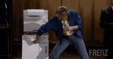 a man is singing into a microphone while standing in front of a stove and oven ..