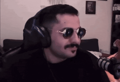 a man with a mustache wearing sunglasses and headphones