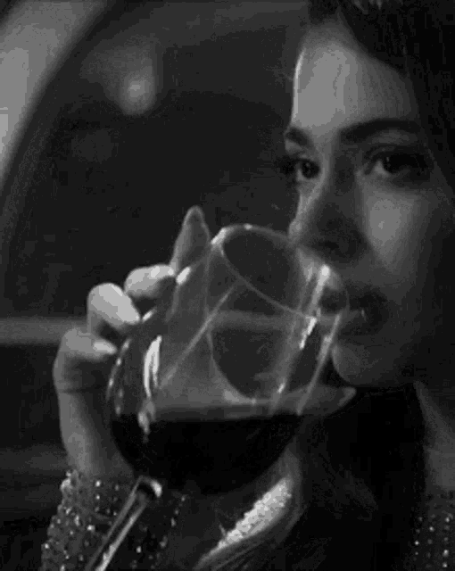 a man with a beard is holding a glass of wine in his hand .