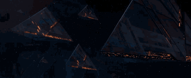 a group of pyramids are lit up in a dark space