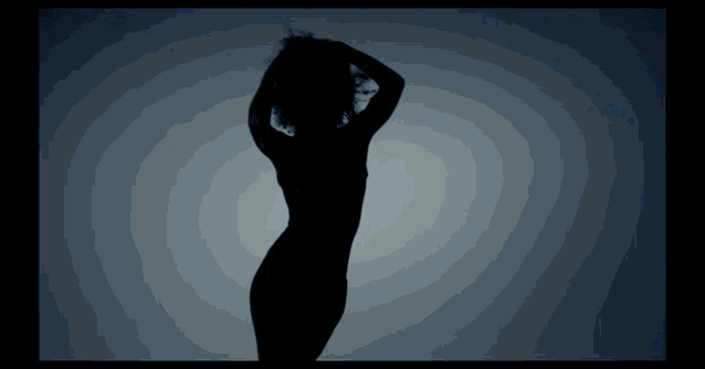 a silhouette of a woman dancing with her hands on her head