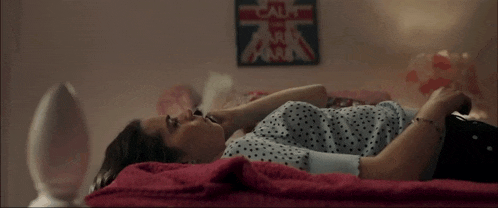 a woman is laying on a bed with a sign that says calm
