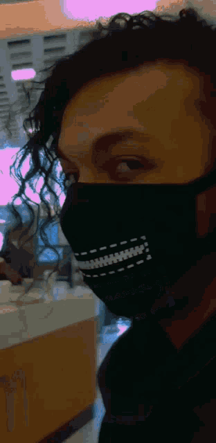 a close up of a person wearing a black mask