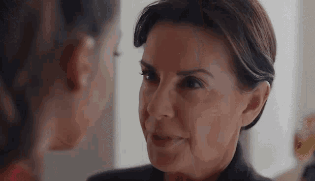 a close up of a woman 's face looking at another woman .