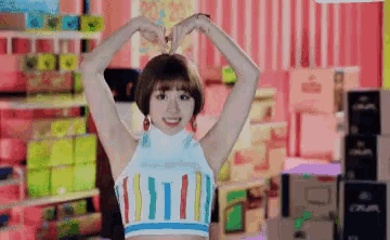 a woman is making a heart with her hands in a store .