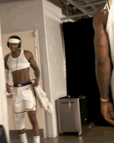 a shirtless basketball player in a locker room with the letter a on his shirt