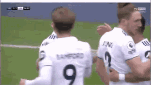 a soccer player wearing a number 9 jersey is hugging another player