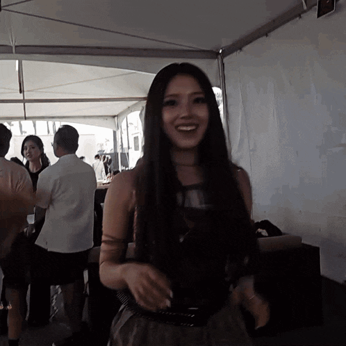 a woman with long hair is smiling in a crowd