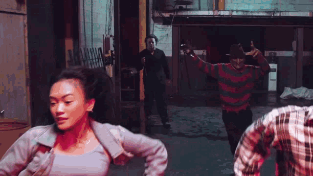 a group of people are dancing in a dark room and one of them is wearing a sweater that says freddy krueger .