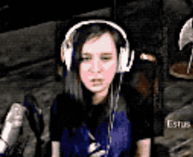a woman wearing headphones is sitting in front of a sign that says est