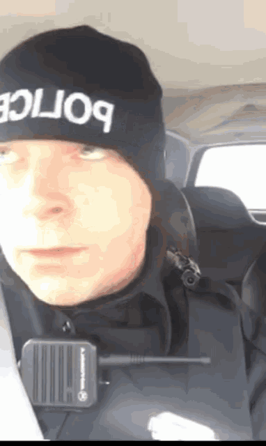 a police officer wearing a black beanie with the word police on it