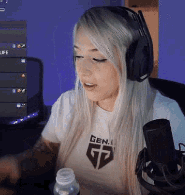 a woman wearing headphones is sitting in front of a microphone and a computer .