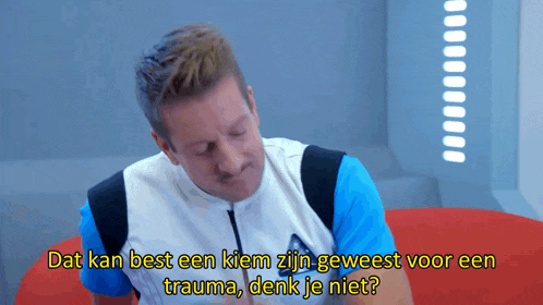 a man sitting on a red couch with the words " dat kan best een kiem zijn geweest voor een trauma denk je niet " above him
