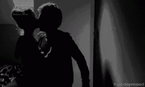 a black and white photo of a person standing in a dark room .