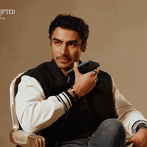 a man in a black and white jacket is sitting in a chair with the word gifted on the bottom right