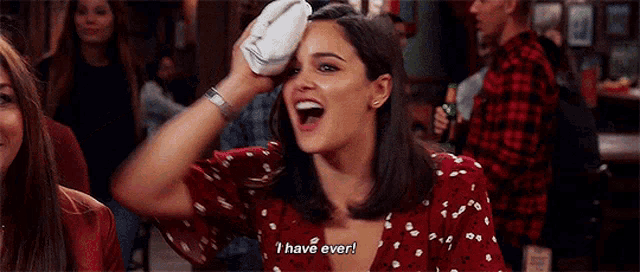 a woman in a red dress is holding a towel over her head and says `` i have ever '' .