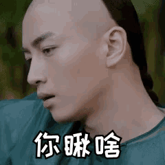 a man with a shaved head and a ponytail is wearing a blue shirt and making a funny face .
