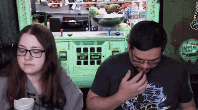 a man and a woman are playing a video game in front of a machine that says left and right .