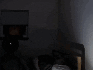 a person in a dark room with a ghost coming out of the ceiling