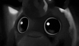 a black and white photo of a stuffed animal with big eyes .
