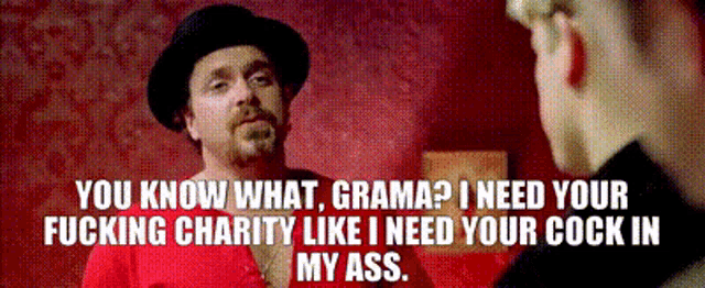 a man in a hat is talking to another man in a red shirt