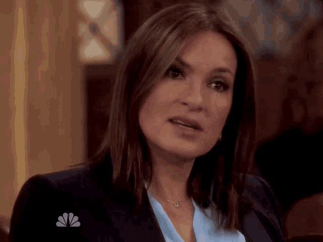 a woman with a nbc logo on her jacket is looking at the camera