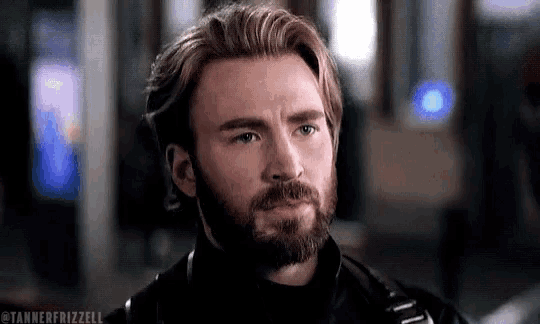 a close up of a man with a beard and long hair