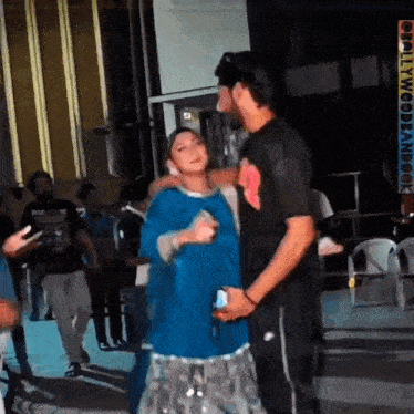 a man and a woman are dancing together in a crowded room .
