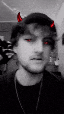 a man wearing a hat with red horns on it