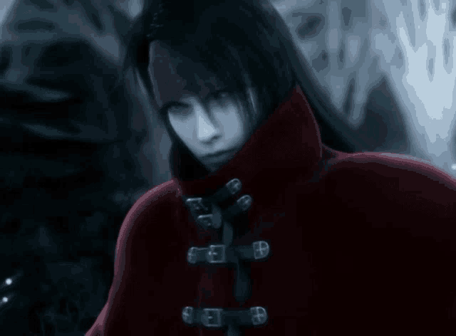 a man with long black hair is wearing a red coat with buckle straps