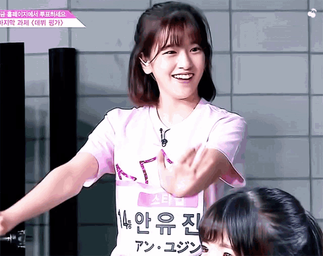 a girl wearing a pink shirt that says ' 14 ' on it