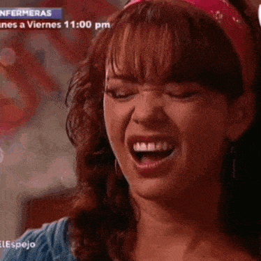 a woman is laughing in front of a screen that says enfermeras on it