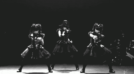 a black and white photo of three people dancing in a dark room