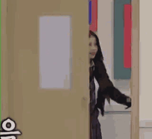 a woman in a school uniform is standing in a doorway .