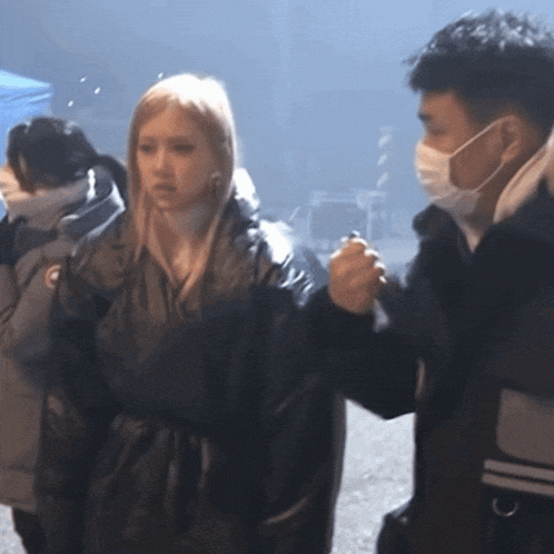a man wearing a mask talks to a woman