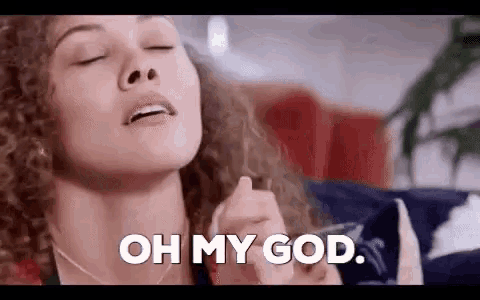 a woman with curly hair is laying on a couch with her eyes closed and saying oh my god .