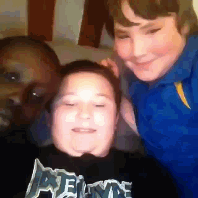 three young boys are posing for a picture and one of them is wearing a black shirt that says aelynx
