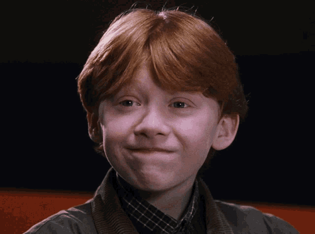 a close up of a young boy with red hair making a face